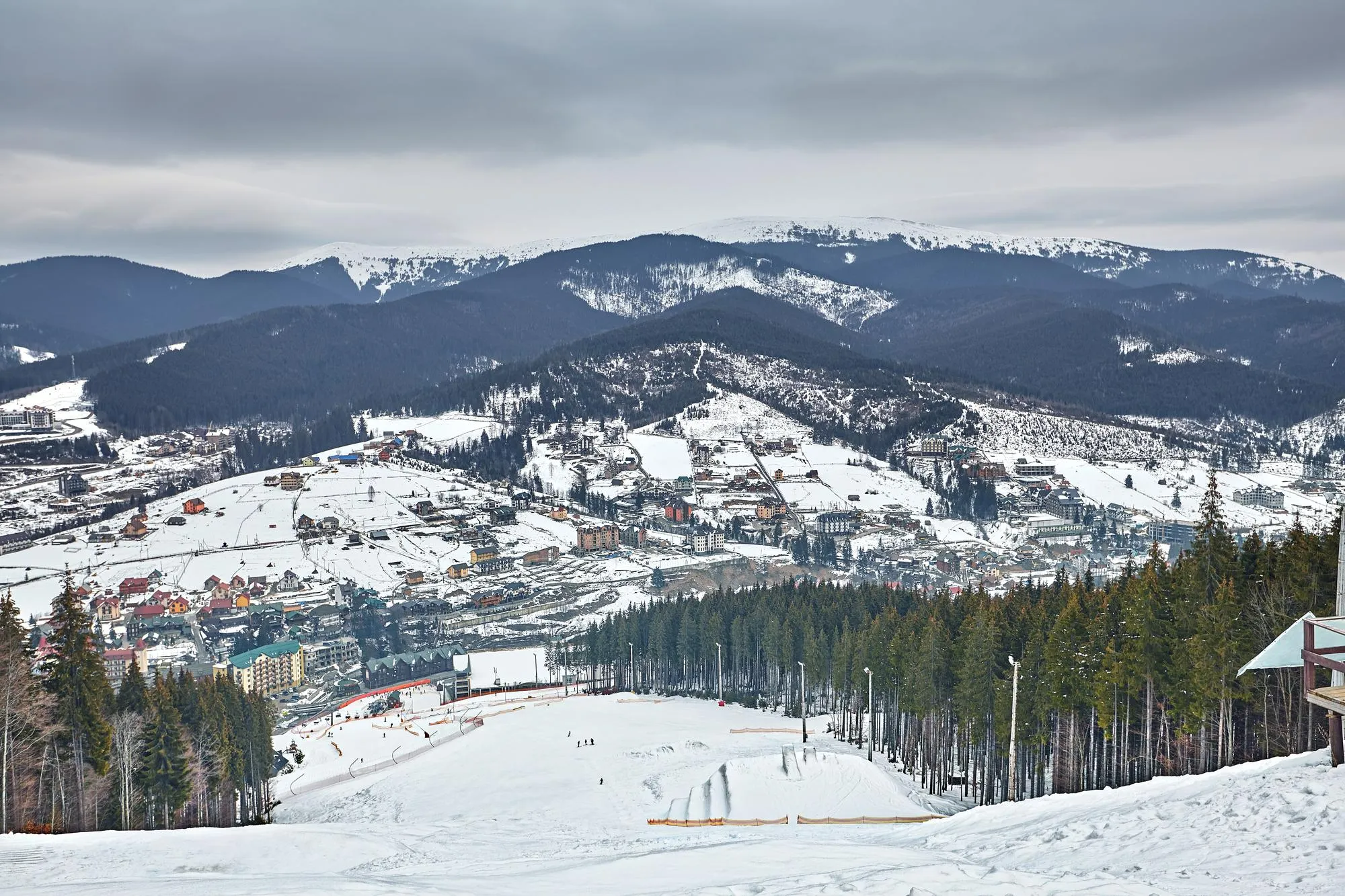 panorama-ski-resort-slope-people-ski-lift-skiers-piste-green-pine-trees-snow-lances-copy-space.webp