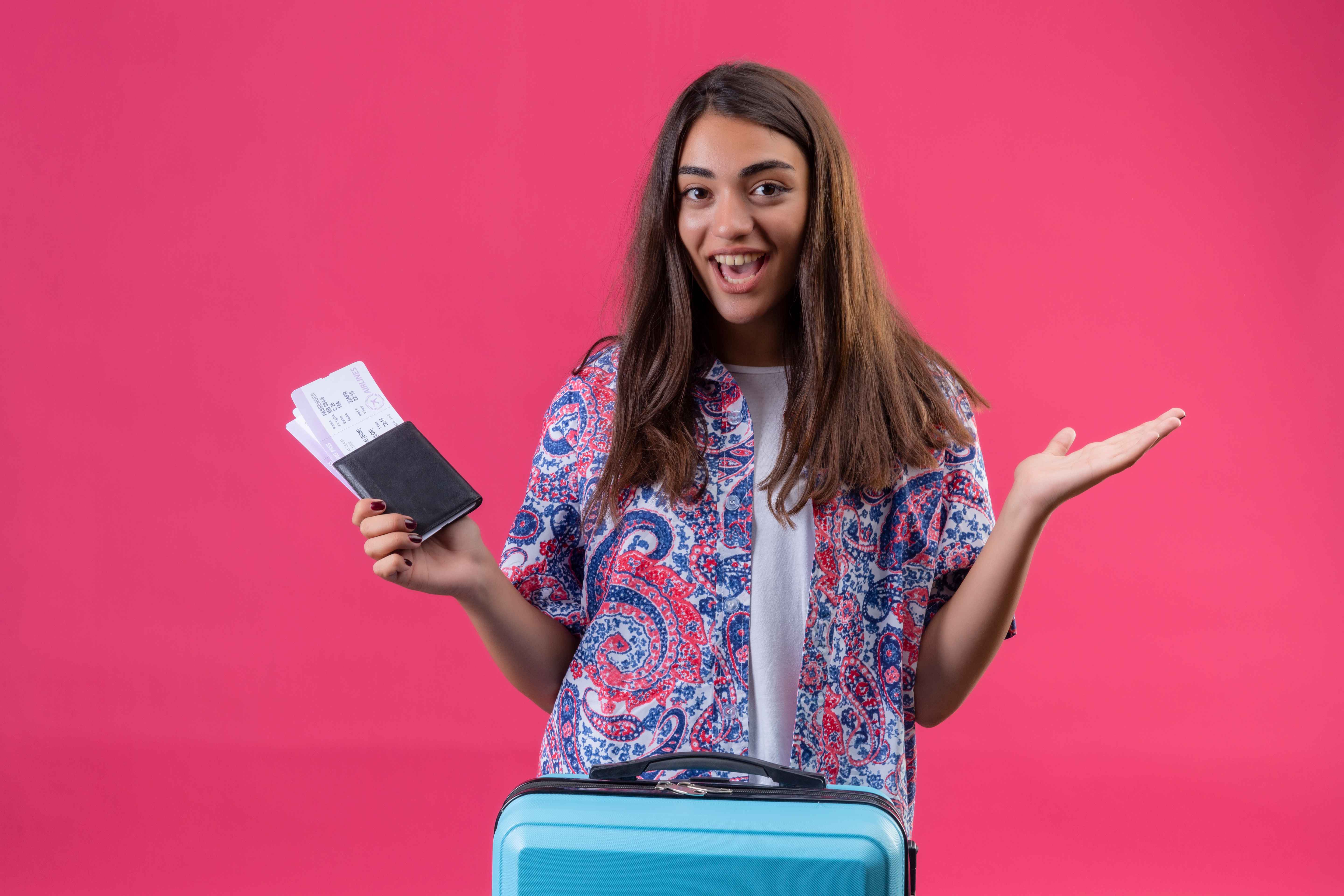young-beautiful-traveler-woman-holding-passport-tickets-exited-joyful-spreading-hands-isolated-pink-wall_11zon.jpg
